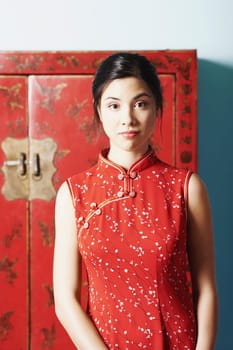 Portrait of a young woman standing in front of a cupboard