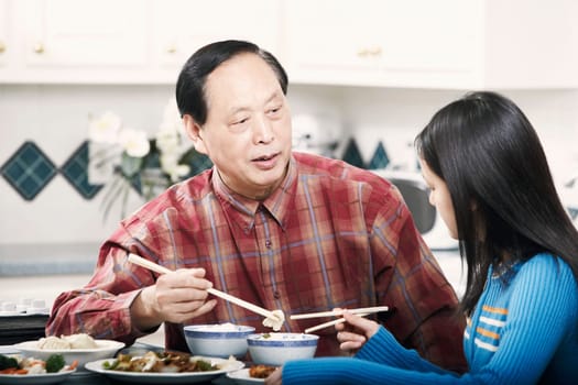 Grandfather and his granddaughter sitting at a table