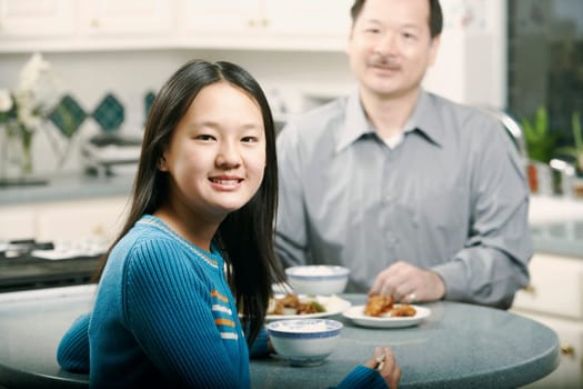Portrait of a girl sitting at a table with her father