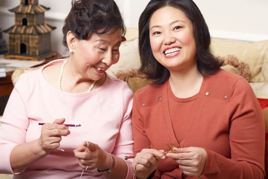 Close-up of a daughter and her mother knitting