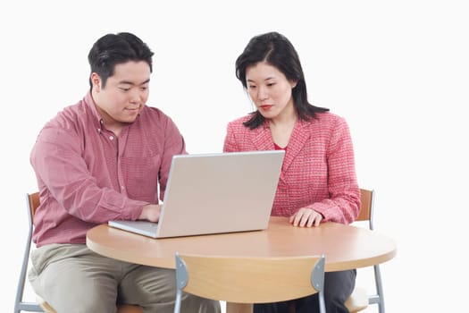 Close-up of a businessman and a businesswoman using a laptop