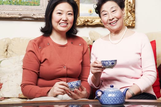 Portrait of a daughter and her mother holding tea cups