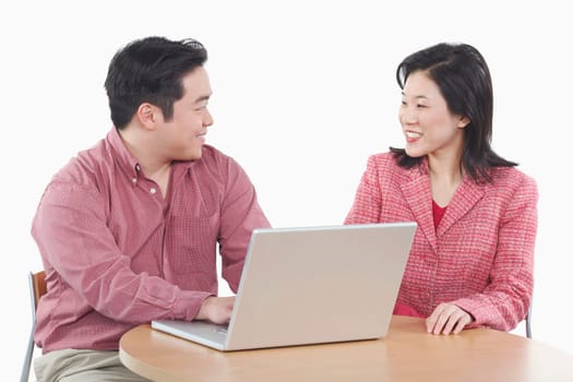 Close-up of a businessman and a businesswoman using a laptop