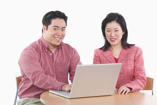 Portrait of a businessman and a businesswoman using a laptop