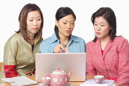 Close-up of three businesswomen in front of a laptop