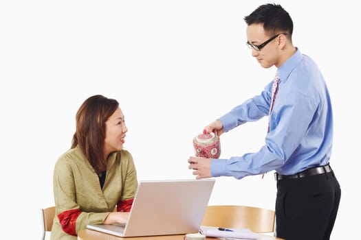 Side profile of a businessman pouring tea into a teacup in front of a businesswoman