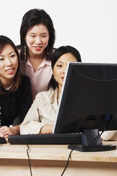Three businesswomen looking at a computer