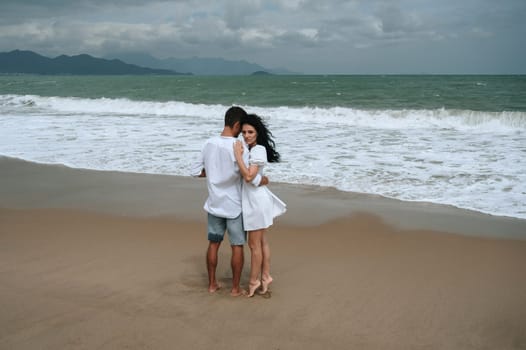 happy couple in love hugs on the beach by the sea in summer on vacation