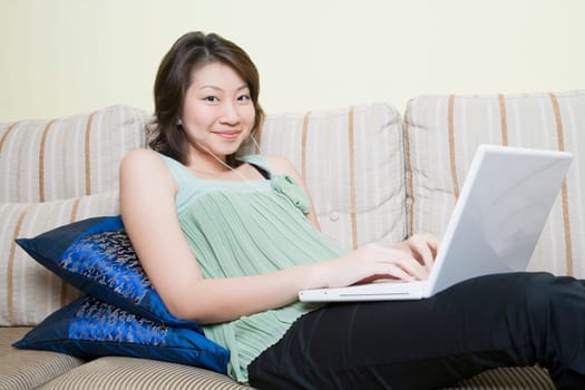 Portrait of a young woman using a laptop and smiling