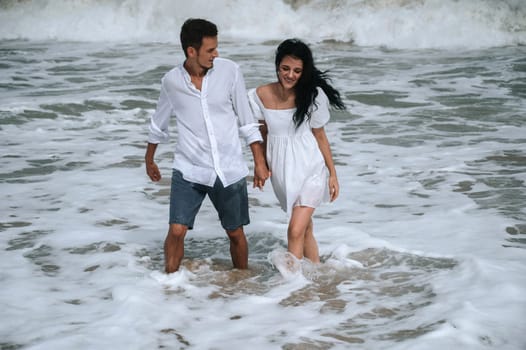 Happy young couple in love on the beach by the sea in summer