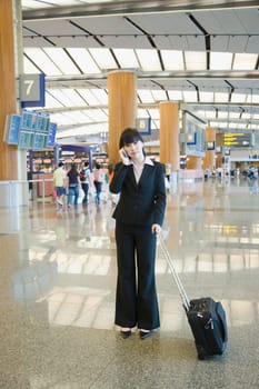 Businesswoman talking on a mobile phone at an airport lounge