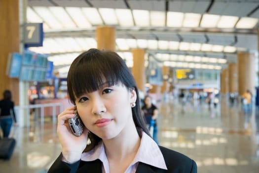 Portrait of a businesswoman talking on a mobile phone at an airport lounge