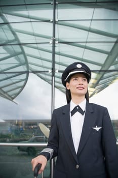 Close-up of a female pilot standing at an airport