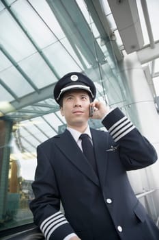 Low angle view of a pilot talking on a mobile phone