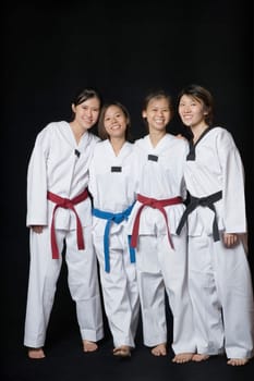 Four young women smiling and standing in gi