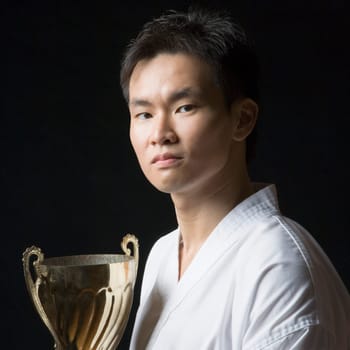 Portrait of a young man holding a trophy
