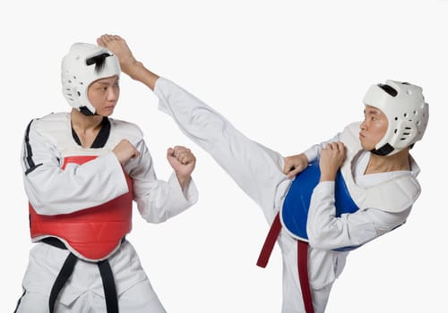 Close-up of a mid adult man practicing kickboxing with a young man