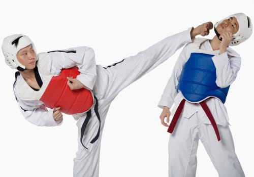 Close-up of a mid adult man practicing kickboxing with a young man