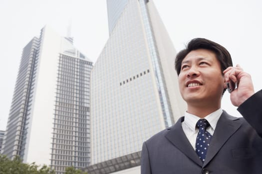 Low angle view of a businessman talking on a mobile phone