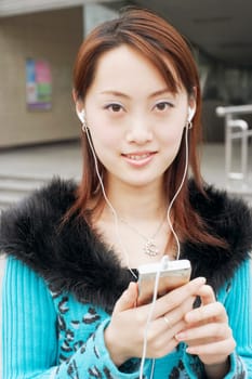 Portrait of a young woman listening to an MP3 player