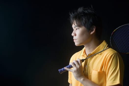 Close-up of a young man holding a badminton racket