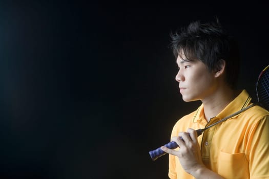 Close-up of a young man holding a badminton racket