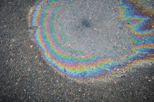 Vibrant rainbow oil spill on wet pavement