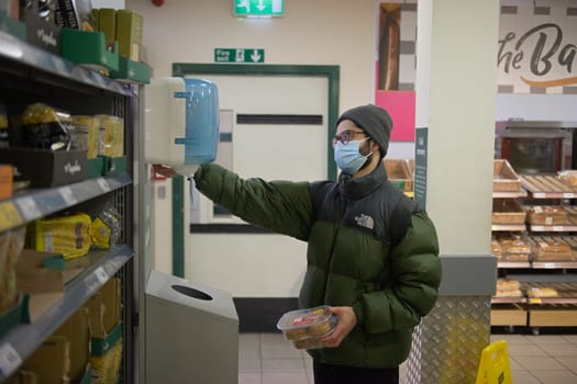 Sheffield, United Kingdom, 14th January, 2021: A Morrisons customer sanitises his hands due to the coronavirus measures in place in store.