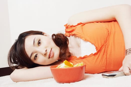 Portrait of a young woman lying down holding a mobile phone