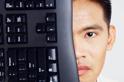 Portrait of a businessman with a computer keyboard in front of his face