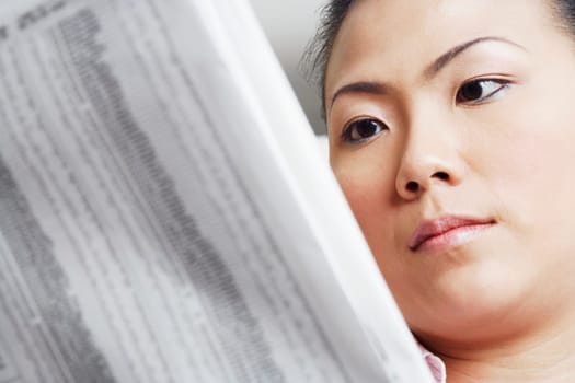 Close-up of a businesswoman reading a financial newspaper