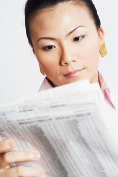 Close-up of a businesswoman reading a financial newspaper