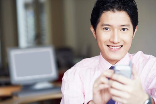Portrait of a businessman operating a personal data assistant with a digitized pen and smiling