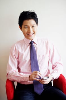Portrait of a businessman holding a hand-held device and smiling