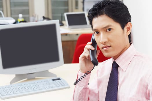 Portrait of a businessman talking on the telephone in an office