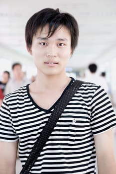 Portrait of a young man standing in a corridor and smiling