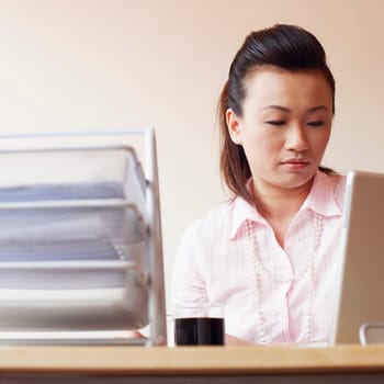 Close-up of a businesswoman using a laptop in an office