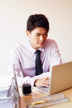 Close-up of a businessman using a laptop in an office