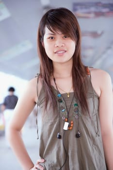Portrait of a young woman standing with her hand on her hip in a corridor