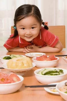 Portrait of a girl sitting at a dining table and smiling