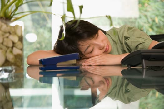 Female office worker napping at a table