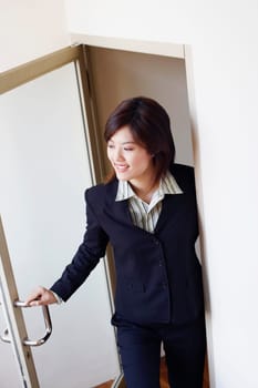 High angle view of a businesswoman opening a door and looking cheerful