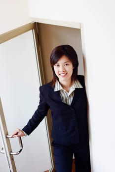 Portrait of a businesswoman opening a door and smiling