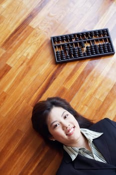 High angle view of a businesswoman lying on the hardwood floor and smiling