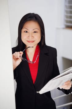 Portrait of a businesswoman holding a newspaper and smiling