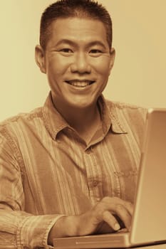 Portrait of a mid adult man using a laptop and smiling