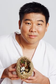 Portrait of a mid adult man holding a birdŽs nest