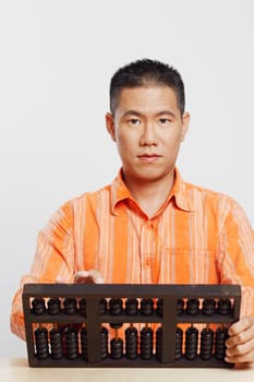 Portrait of a mid adult man using an abacus