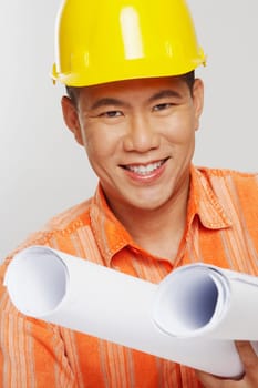 Portrait of a male architect holding two blueprints and smiling