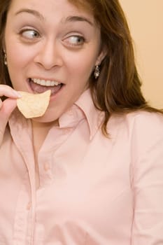 Close-up of a mid adult woman eating a potato chip